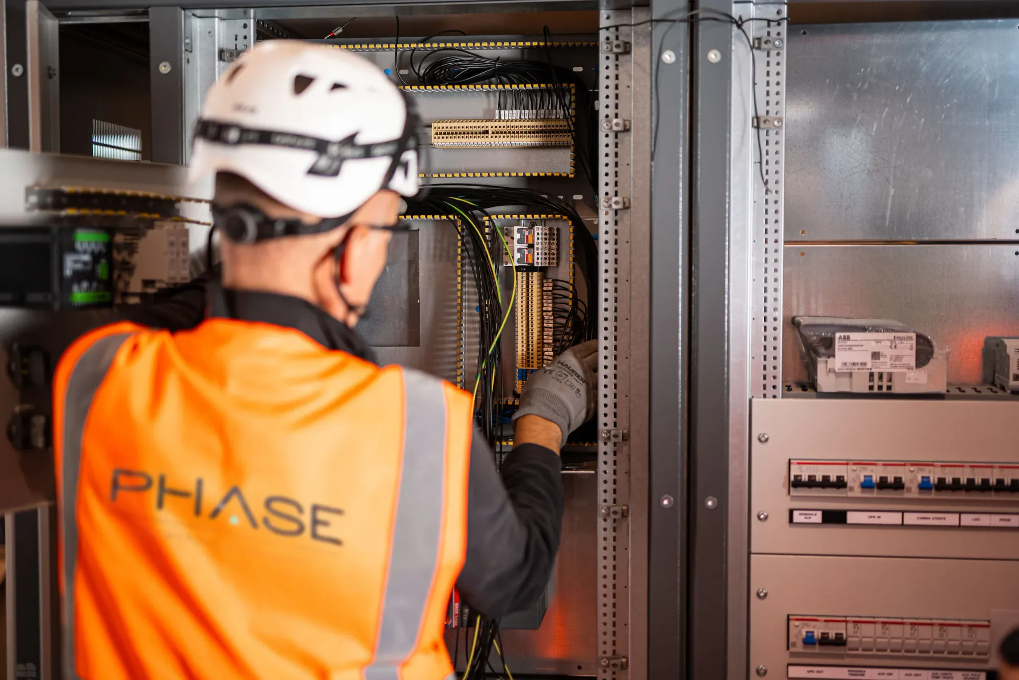Tecnico PHASE al lavoro su un quadro elettrico durante un adeguamento
